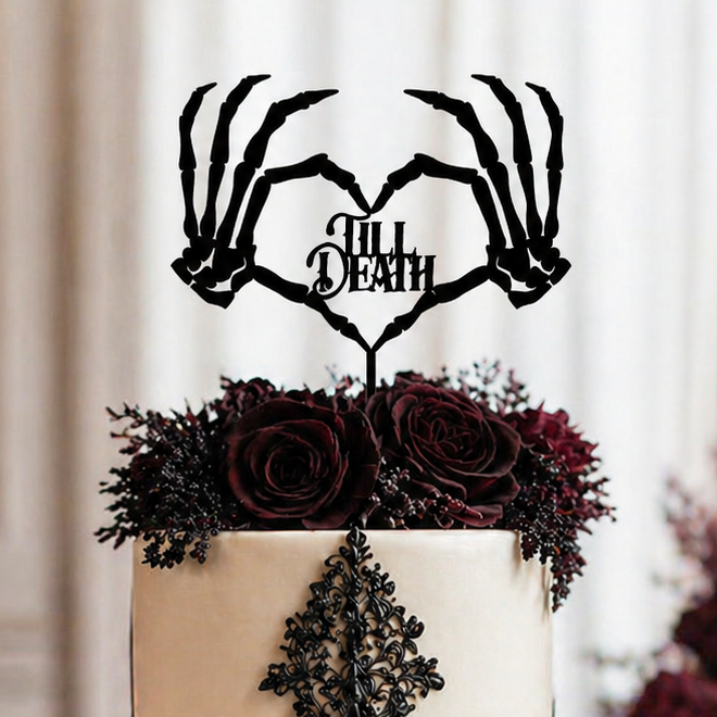Decorative wedding cake with black lace detailing and 'Till Death' topper in a elegant setting.